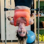 Woman hangs upside down in a gym.